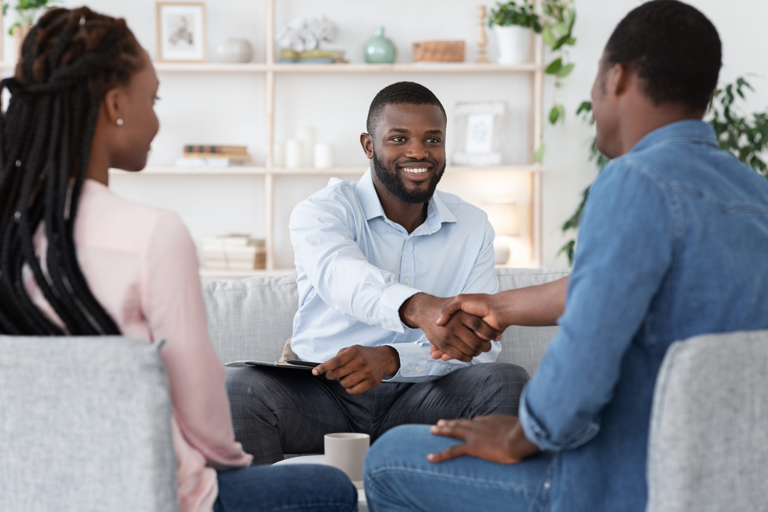 thankful-black-couple-and-marital-therapist-shaking-hands-after